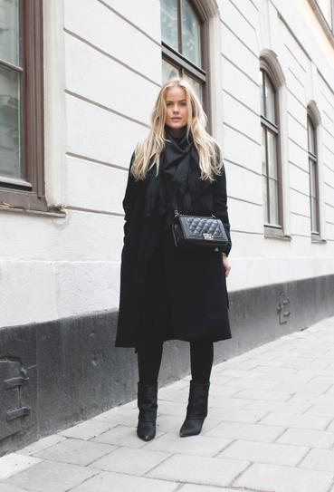 Девушка в черном пальто и коротких сапогах