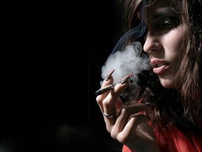 Женщина курит сигарету